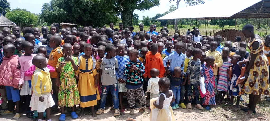 Children gathered outdoors during a community support day